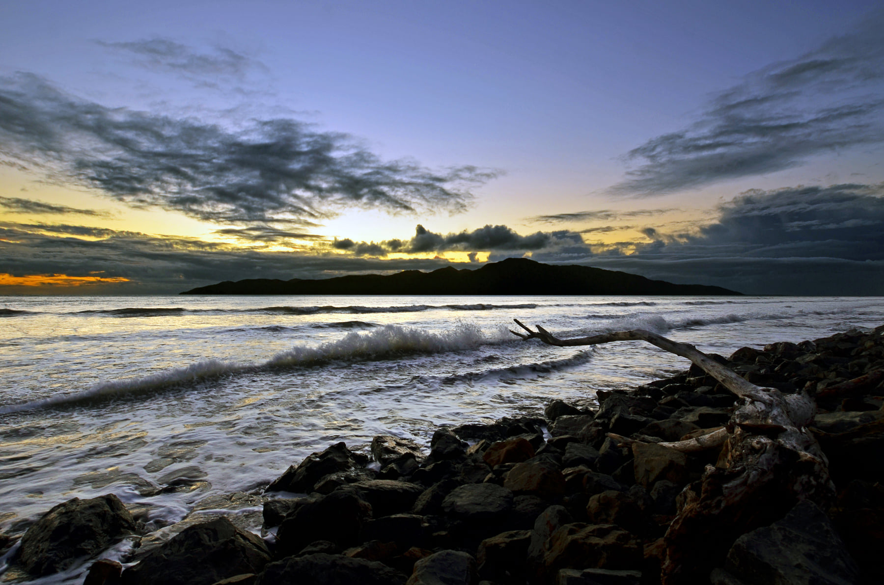 Stoney beach coastline wave arriving. Kapti Island in the distance