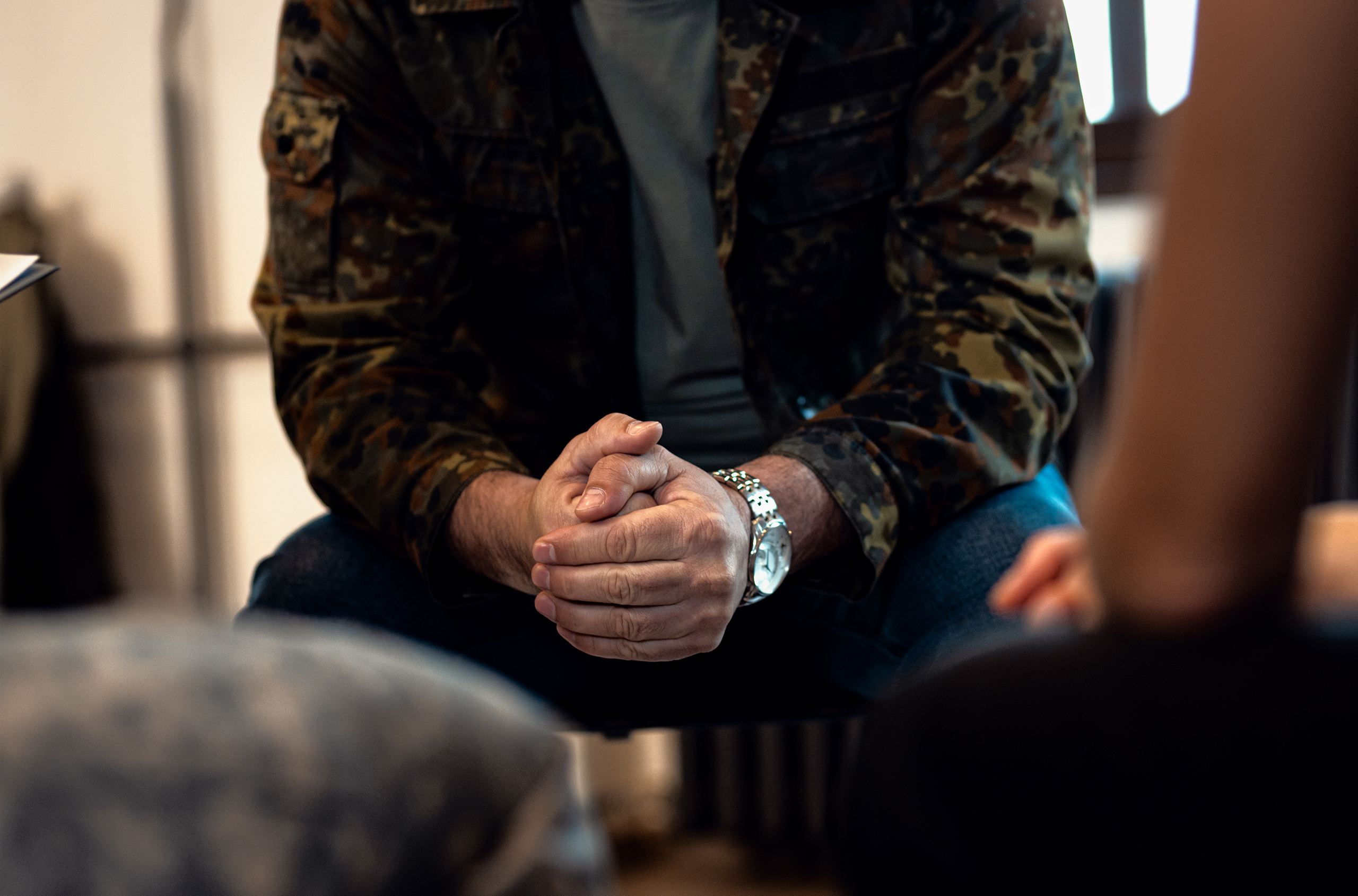 Man sitting clasping his hands