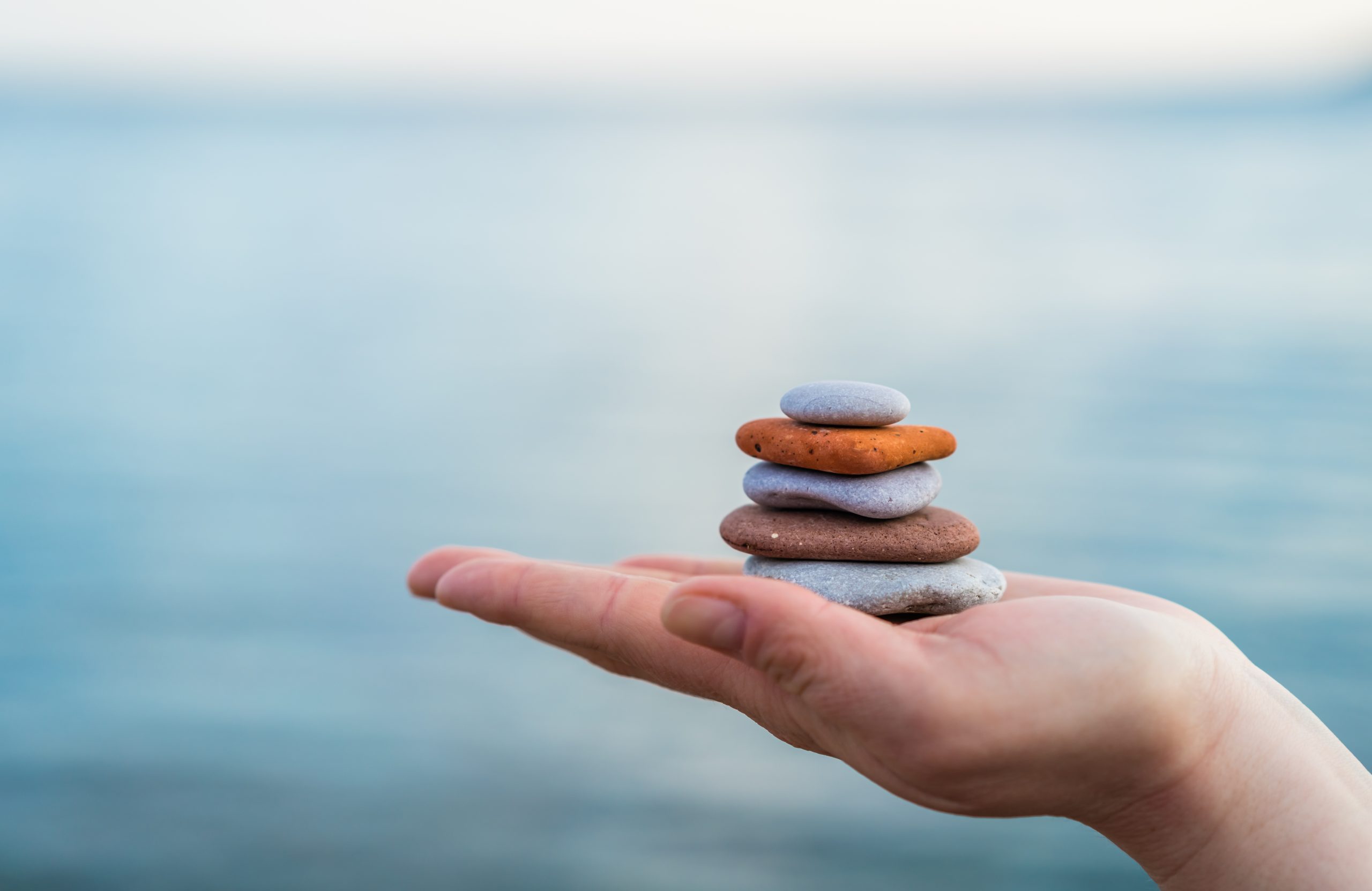Pile of stacked stones large to small in human hand